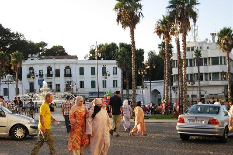 Plaza de Tánger al atardecer con palmeras, viajeras y fuente en el centro