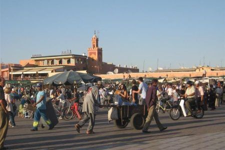 Plaza Yamaa el Fna durante viaje a Marrakech con artistas callejeros y turistas