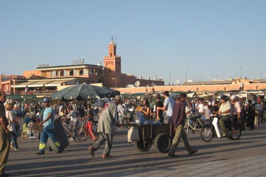 Plaza Yamaa el Fna durante viaje a Marrakech con artistas callejeros y turistas