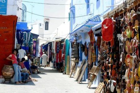 Calle comercial de la medina de Asilah con tiendas de artesanía y alfombras a ambos lados
