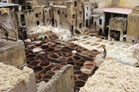 Vista aérea de las tenerías tradicionales de Fez con cubas de tinte y trabajadores entre los bloques de cuero