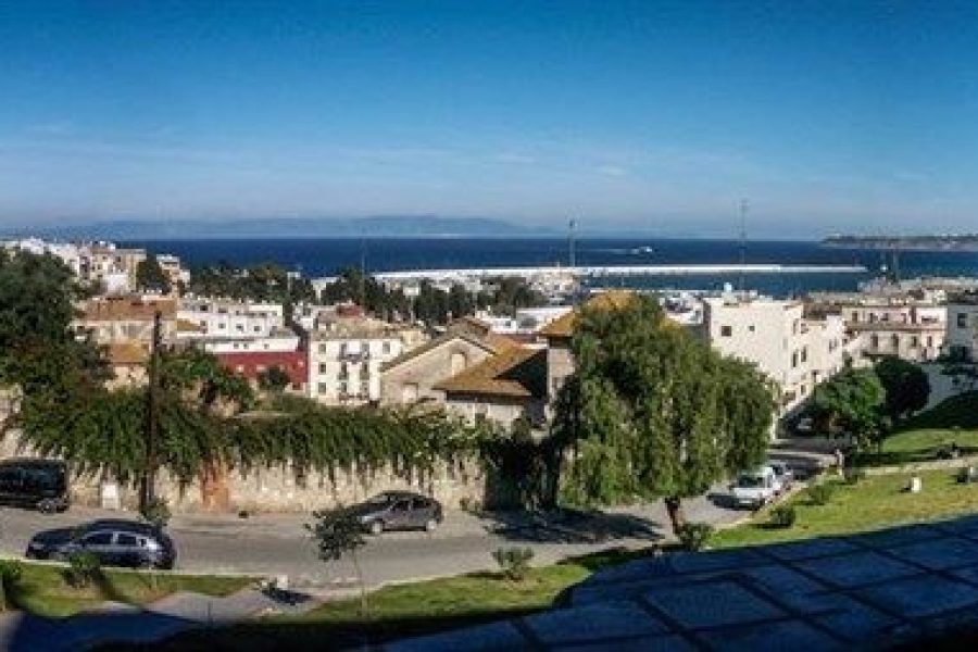 Vista panorámica del ensanche de Tetuán con palmeras y el estrecho de Gibraltar al fondo