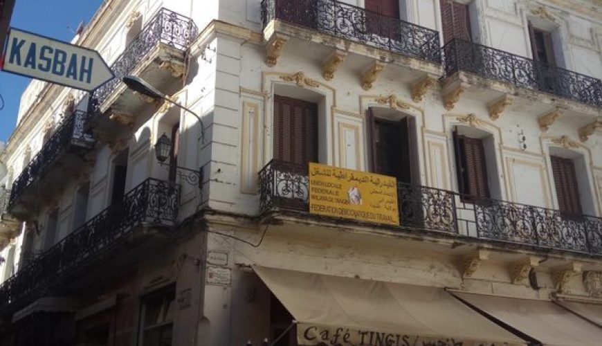 Calle de la Kasbah de Tánger con cartel indicativo y el Café Tingis en primer plano