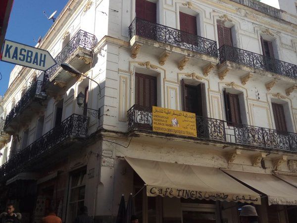 Calle de la Kasbah de Tánger con cartel indicativo y el Café Tingis en primer plano