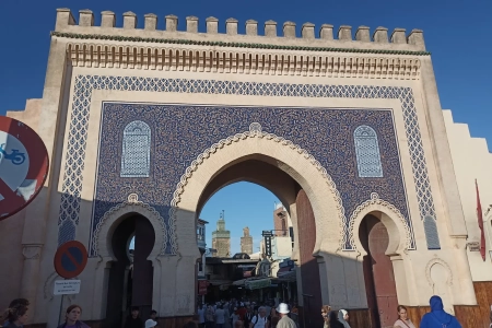 Puerta azul de Bab Boujloud con el minarete verde al fondo en Fez